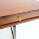 Wooden desk with drawers and black lacquered legs.