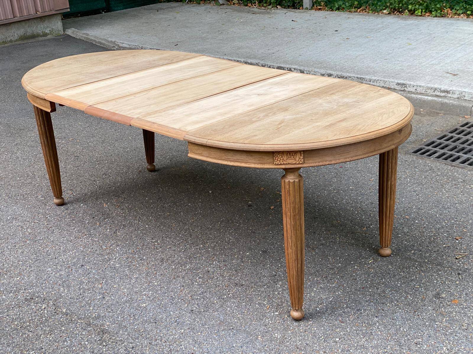 Large stripped solid oak dining table in Louis XVI style with 3 extensions.