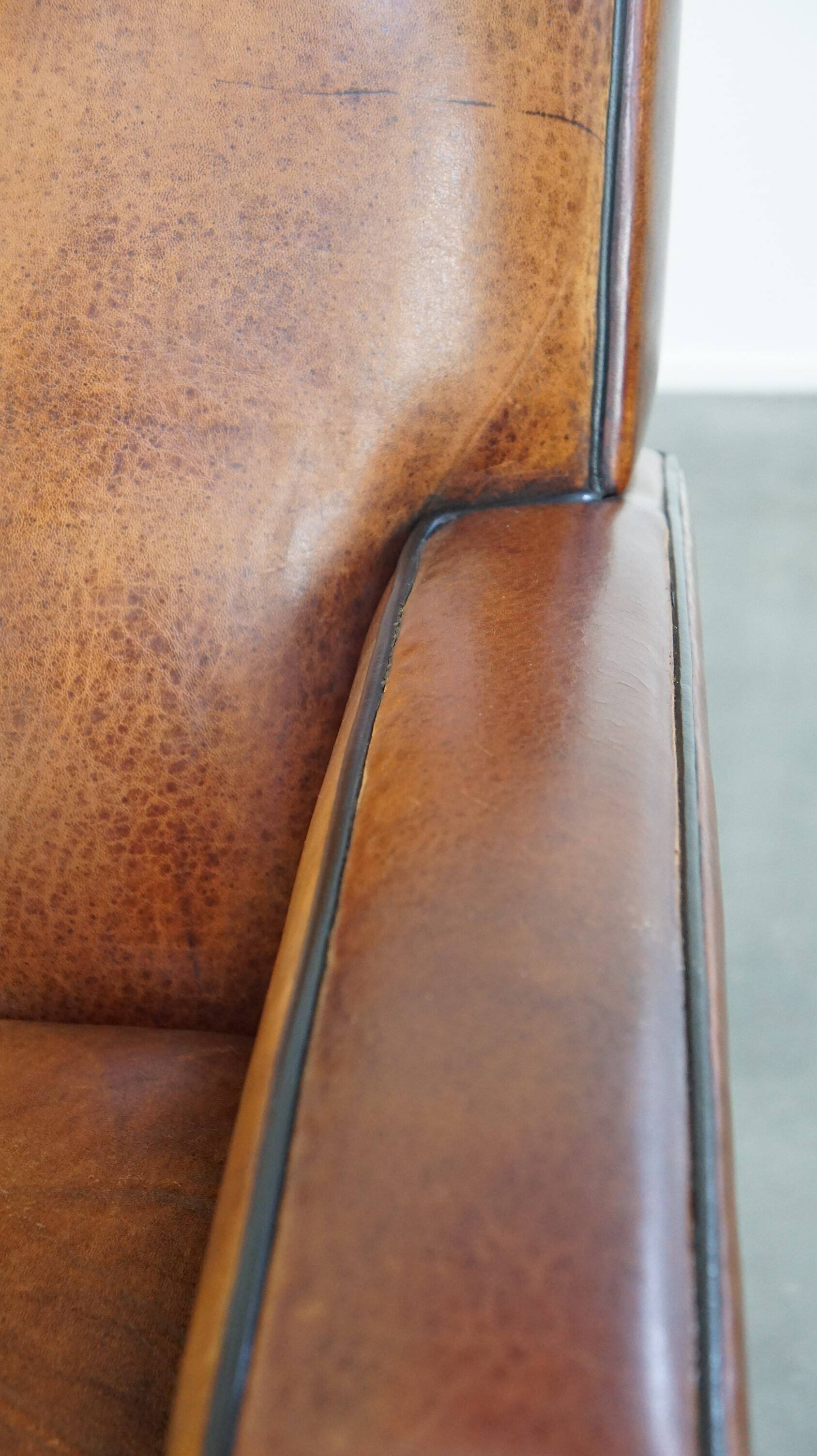 Art Deco design sheepskin leather armchair with a stunning patina