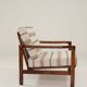 Fauteuil vintage avec des coussins en tissu naturel rayé.