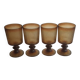 Set of four thick amber glass stemmed glasses.