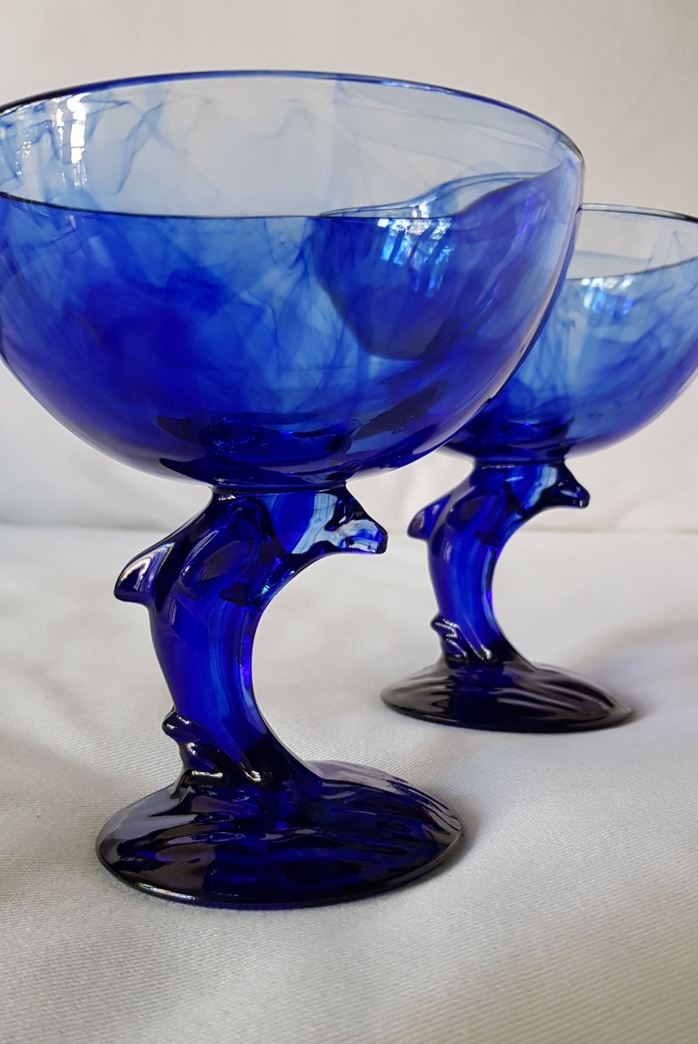 Set of 2 dolphin dessert cups in blue glass.