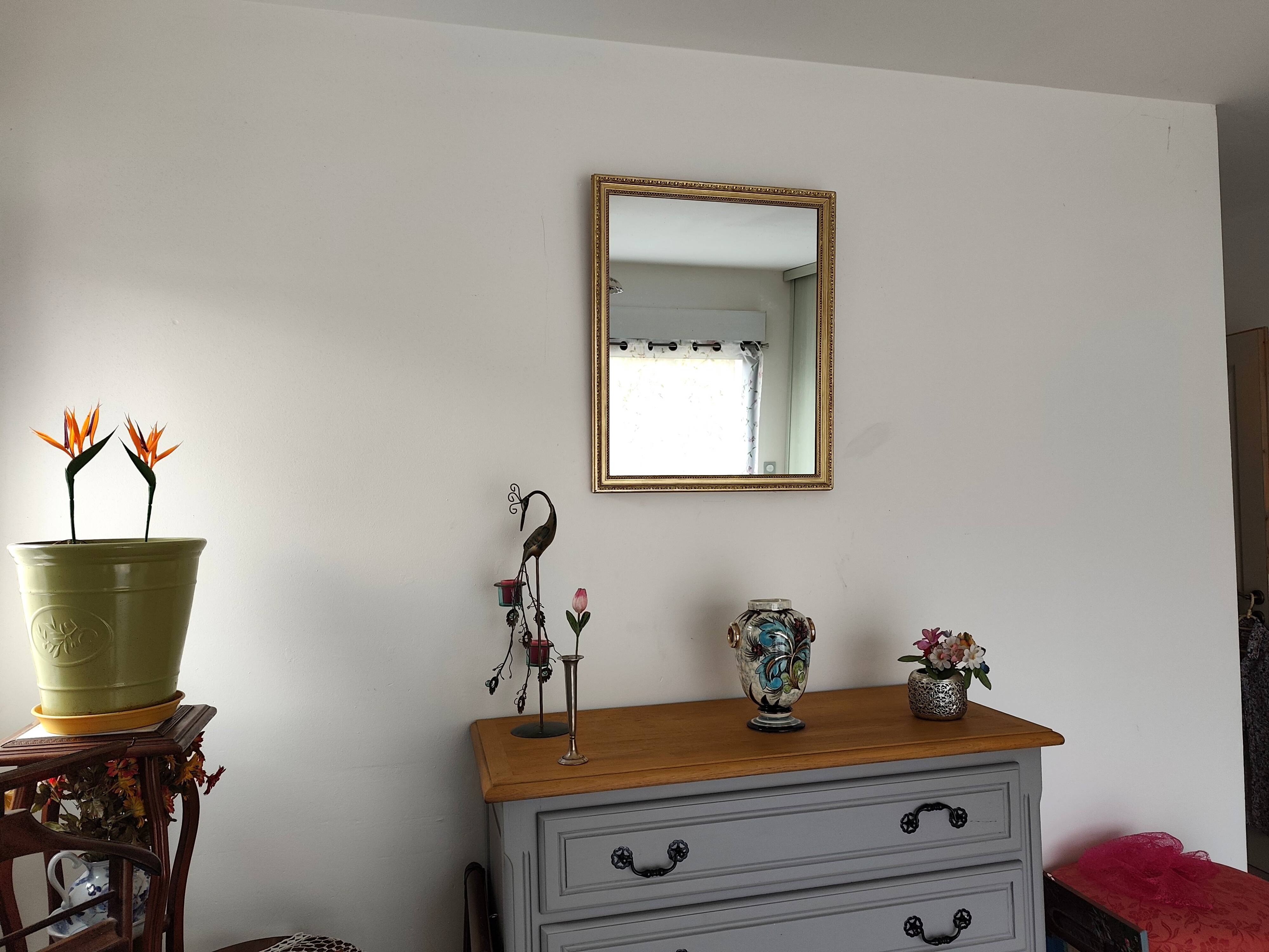 Antique mirror with a gilded frame and beaded border.