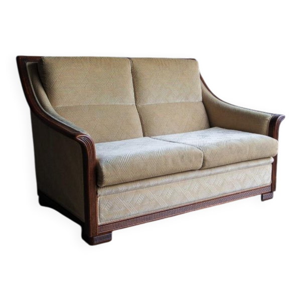 Canapé deux places Art déco en tissu beige avec cadre en bois orné brun foncé.