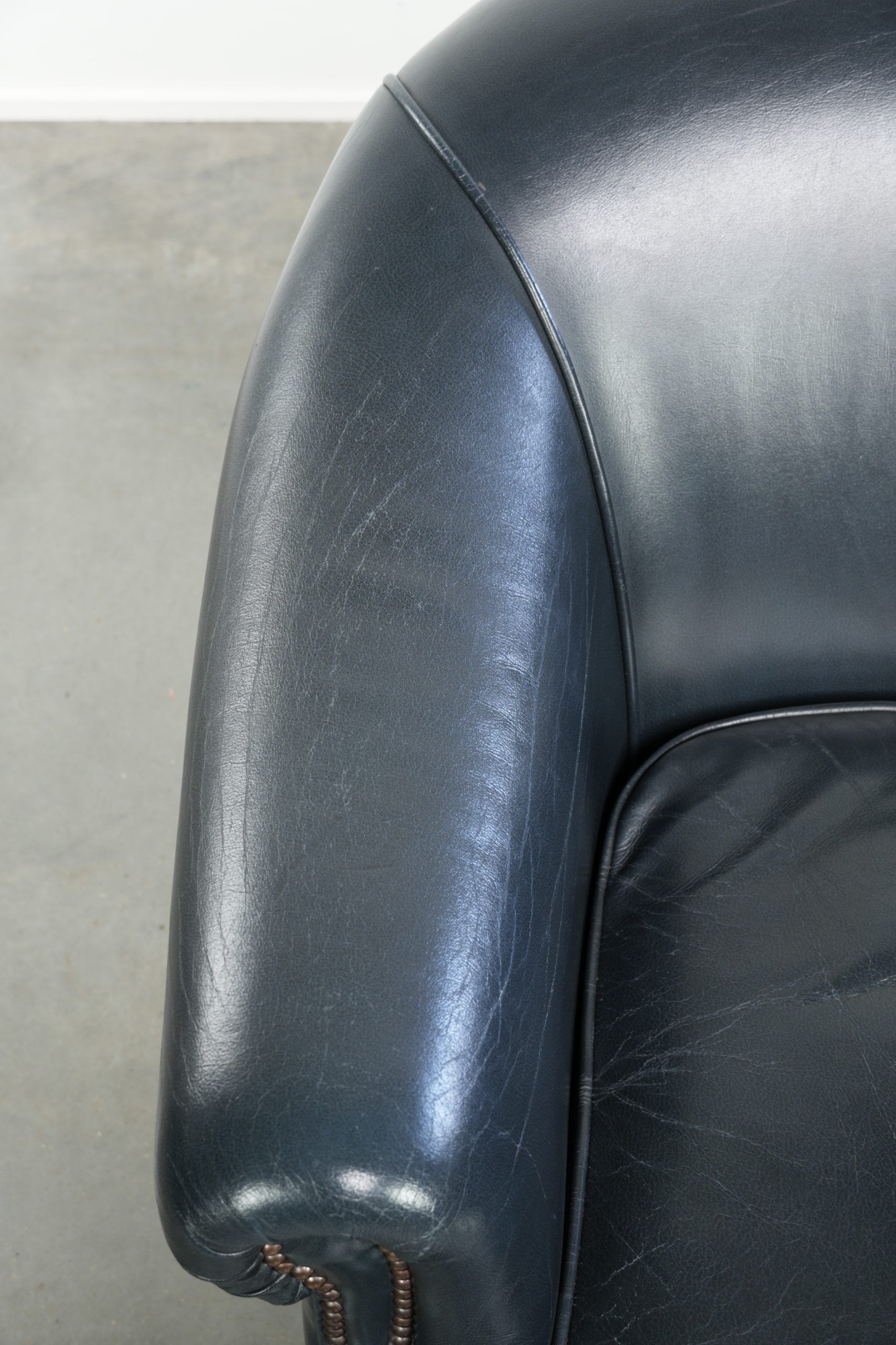 Dark blue club armchair made of cowhide leather with a timeless design