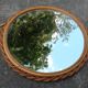 Small round mirror with rattan frame, vintage 70s