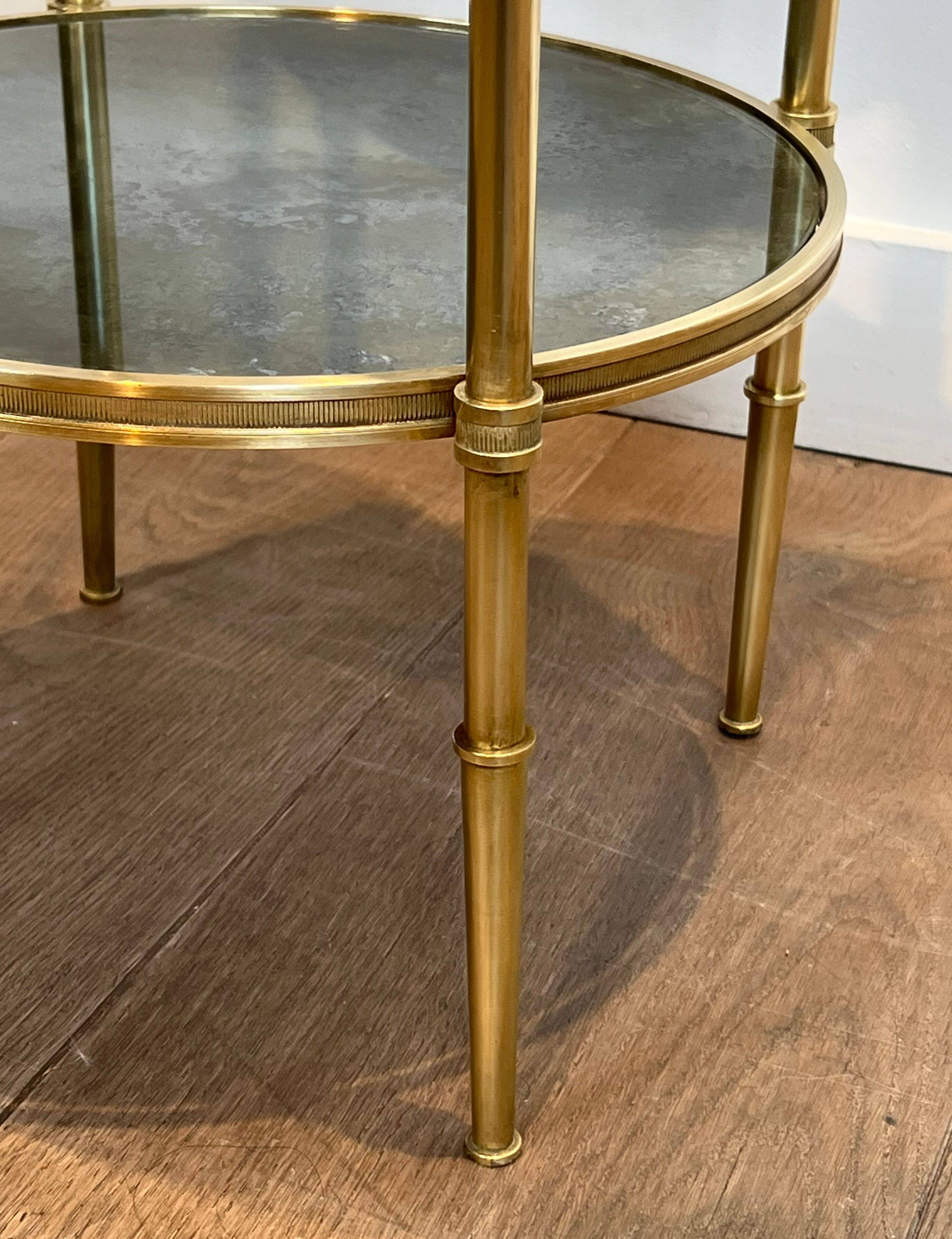 Round bronze side table with triple shelves of églomisé mirrors from Maison Baguès