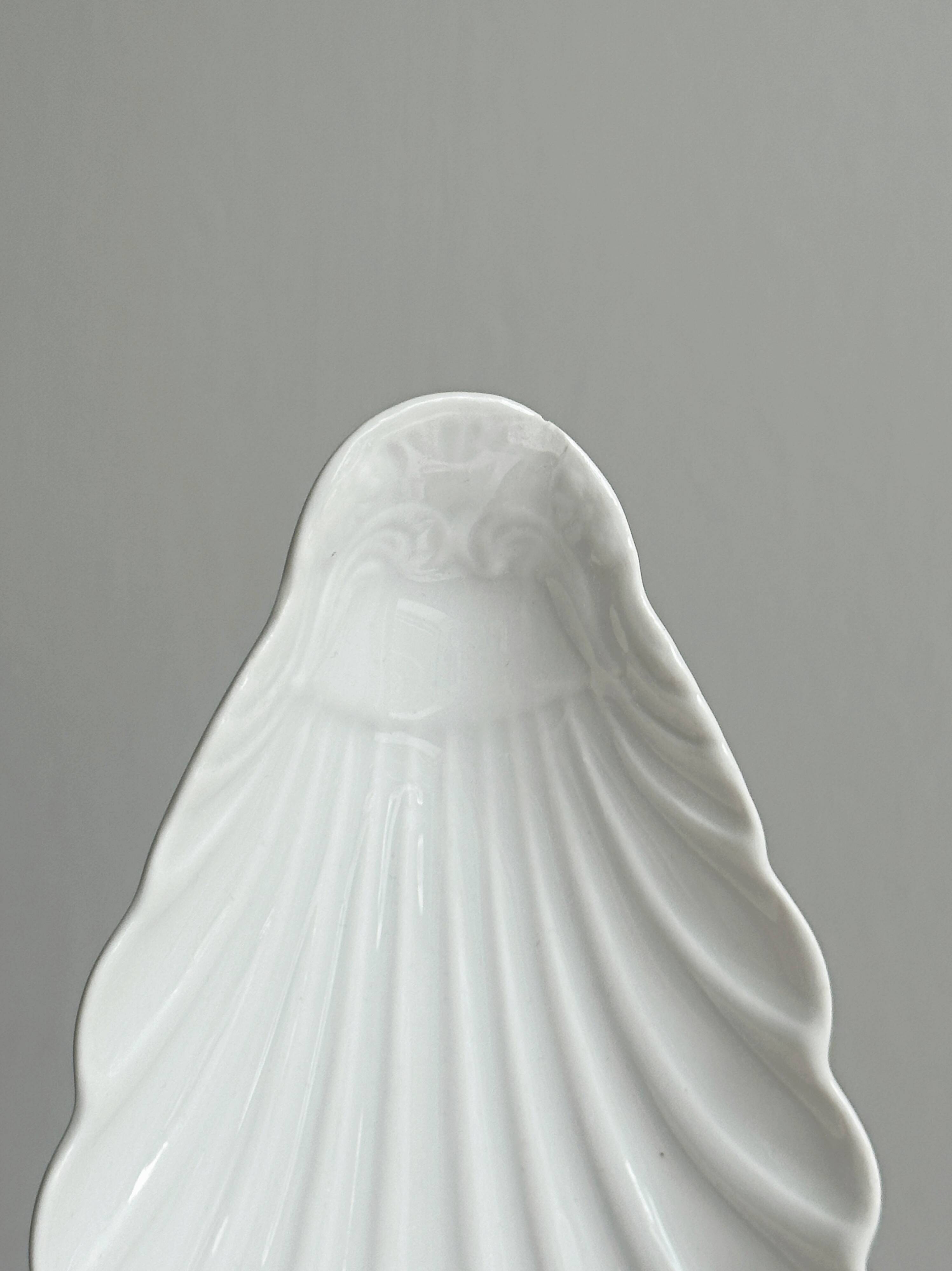 Set of white porcelain ramekins, ribbed shell shape.