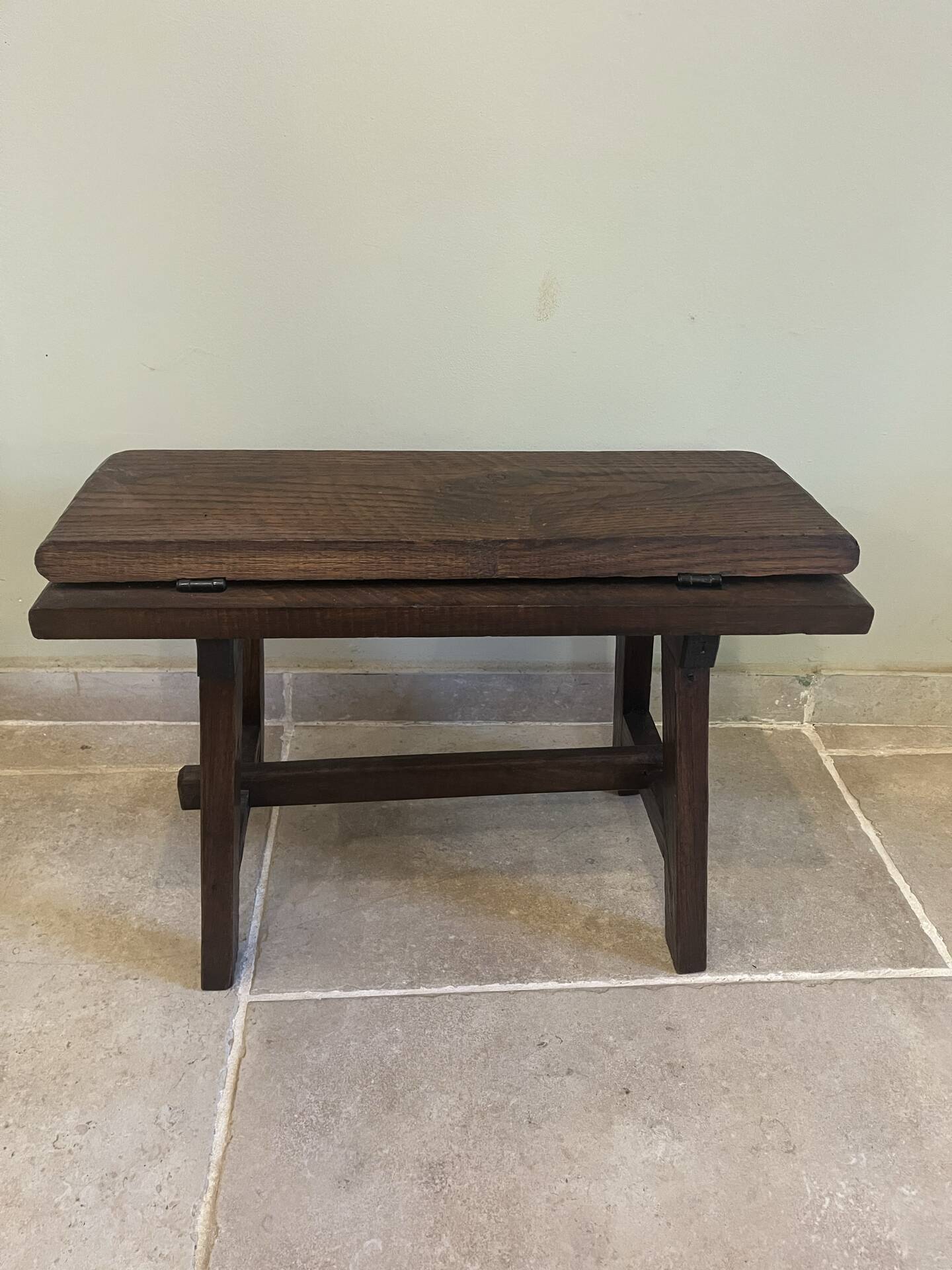 Small antique wooden bench with a folding backrest.