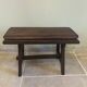 Small antique wooden bench with a folding backrest.