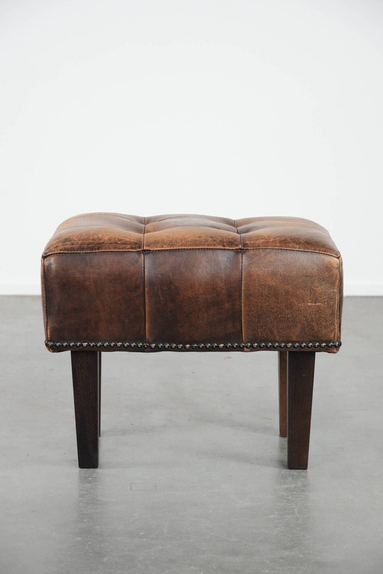 Beautiful sheepskin ottoman on high legs and beautiful warm colours
