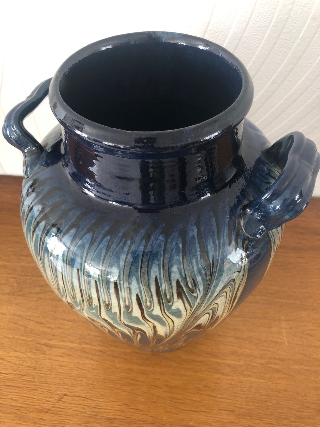 Vase in glazed ceramic decoration drips on blue background