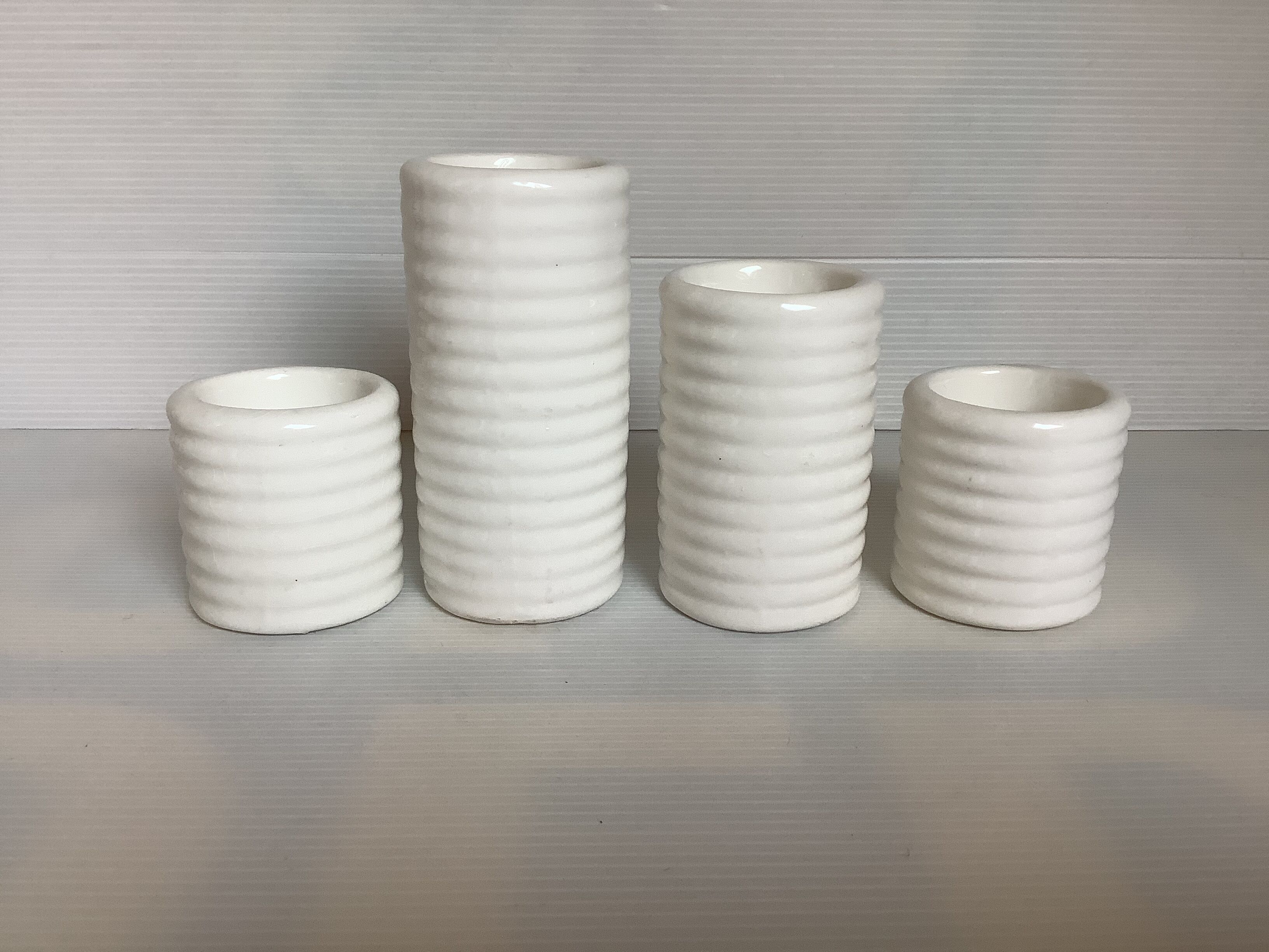 Four white earthenware candle holders