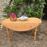 Folding drop-leaf table made of raw solid wood.