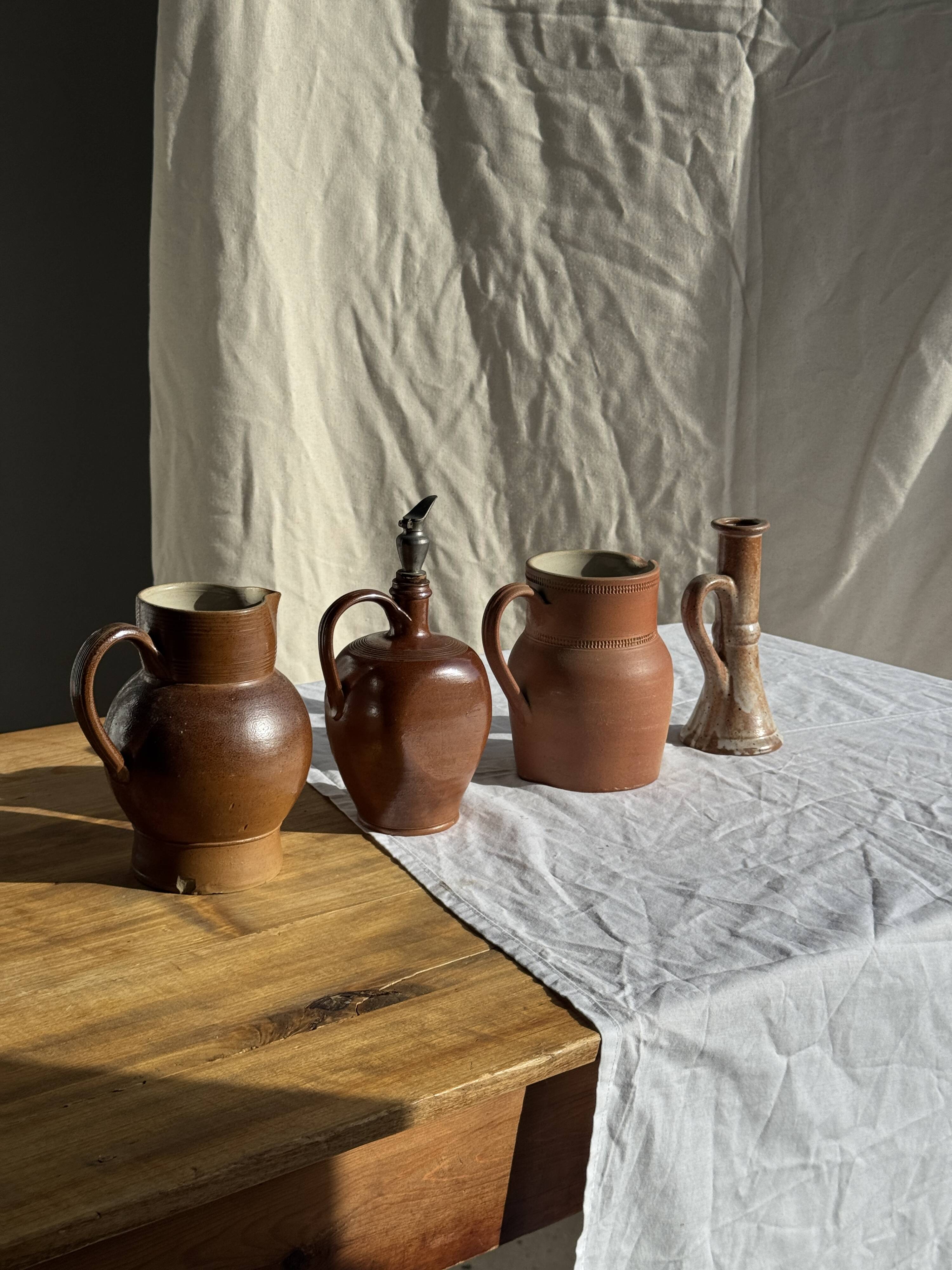 Ancient stoneware jug with a pewter spout.
