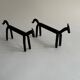 Pair of animal-shaped wrought iron and hammered fire dogs in primitive brutalist style.
