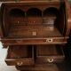 Antique solid wood secretary with a drop-down cylinder compartment.