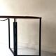 Modernist round folding dining table in wood and metal.