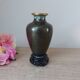 Small black cloisonné vase decorated with yellow and pink cherry blossoms, vase on wooden base