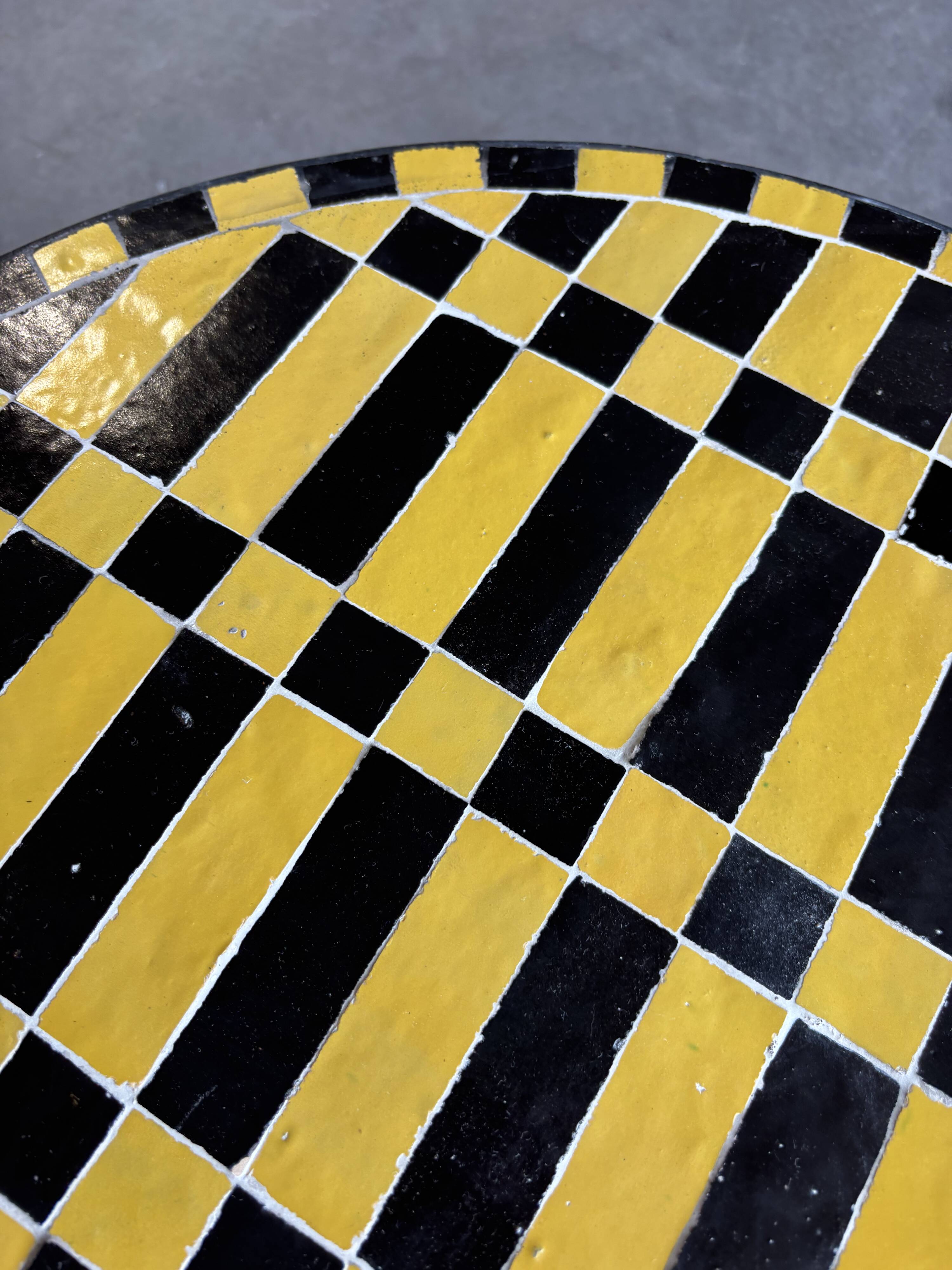 Round coffee table in yellow and black zellige, Moroccan graphic pattern.