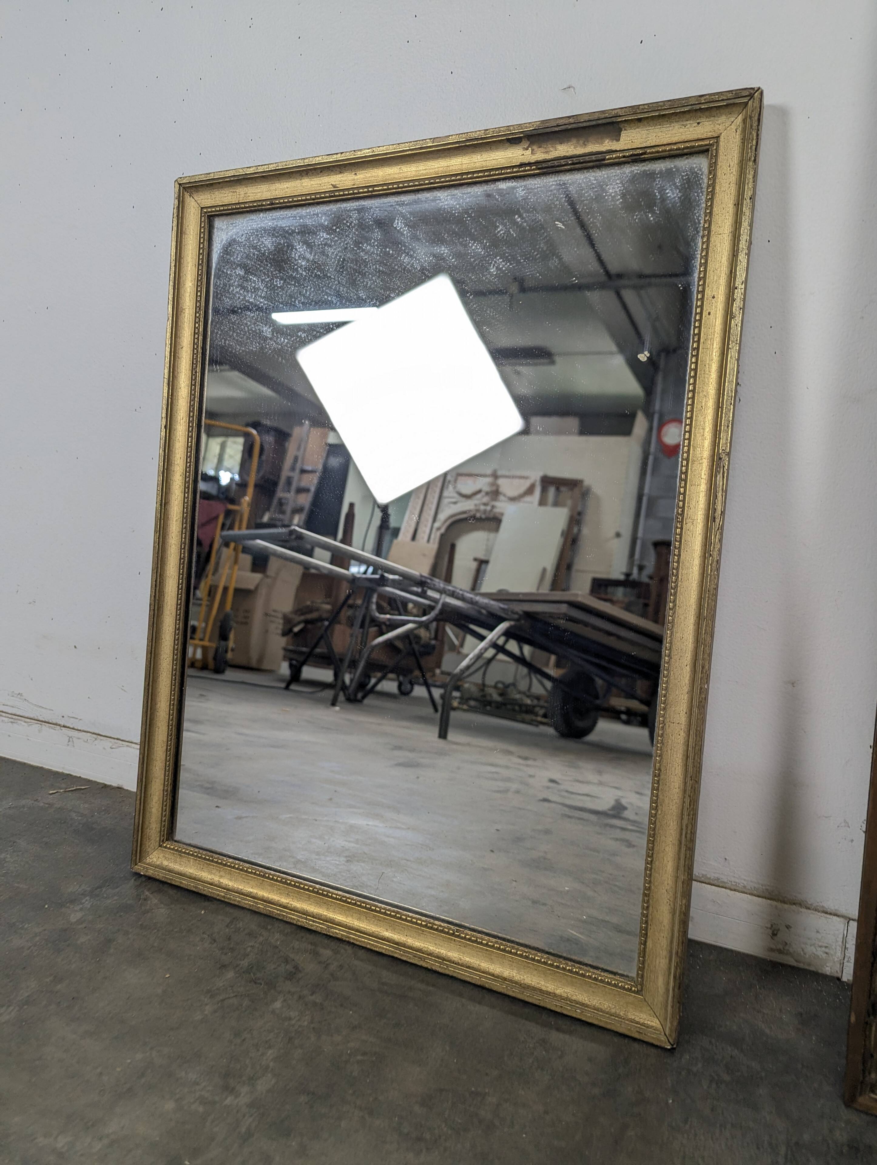 Rectangular mirror with a gold wooden frame.
