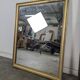 Rectangular mirror with a gold wooden frame.