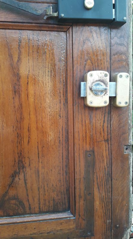 Oak entrance door and its frame and transom, wrought iron gates