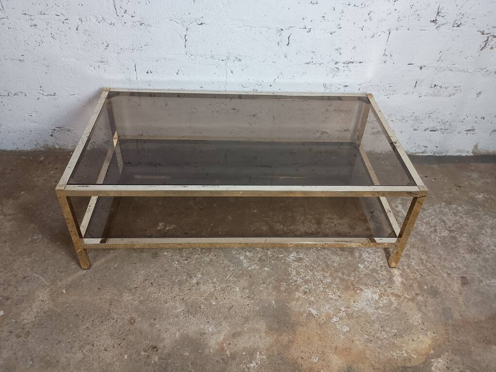 1970s coffee table in brass with a double smoked glass top.