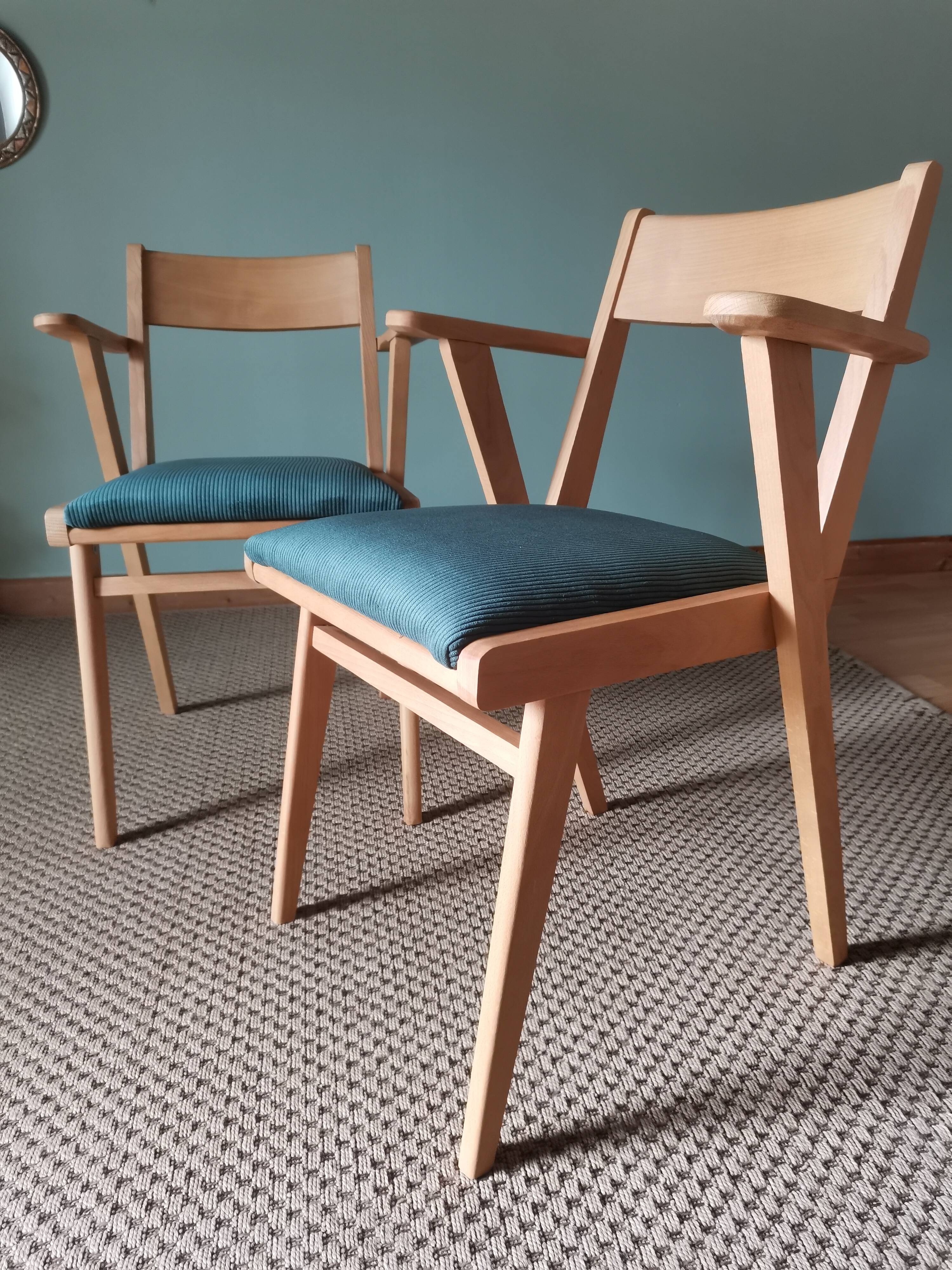 Scandinavian armchairs with green tapered legs.
