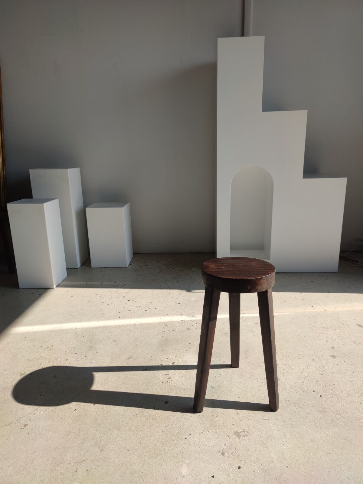 Small high tripod stool in brown solid wood