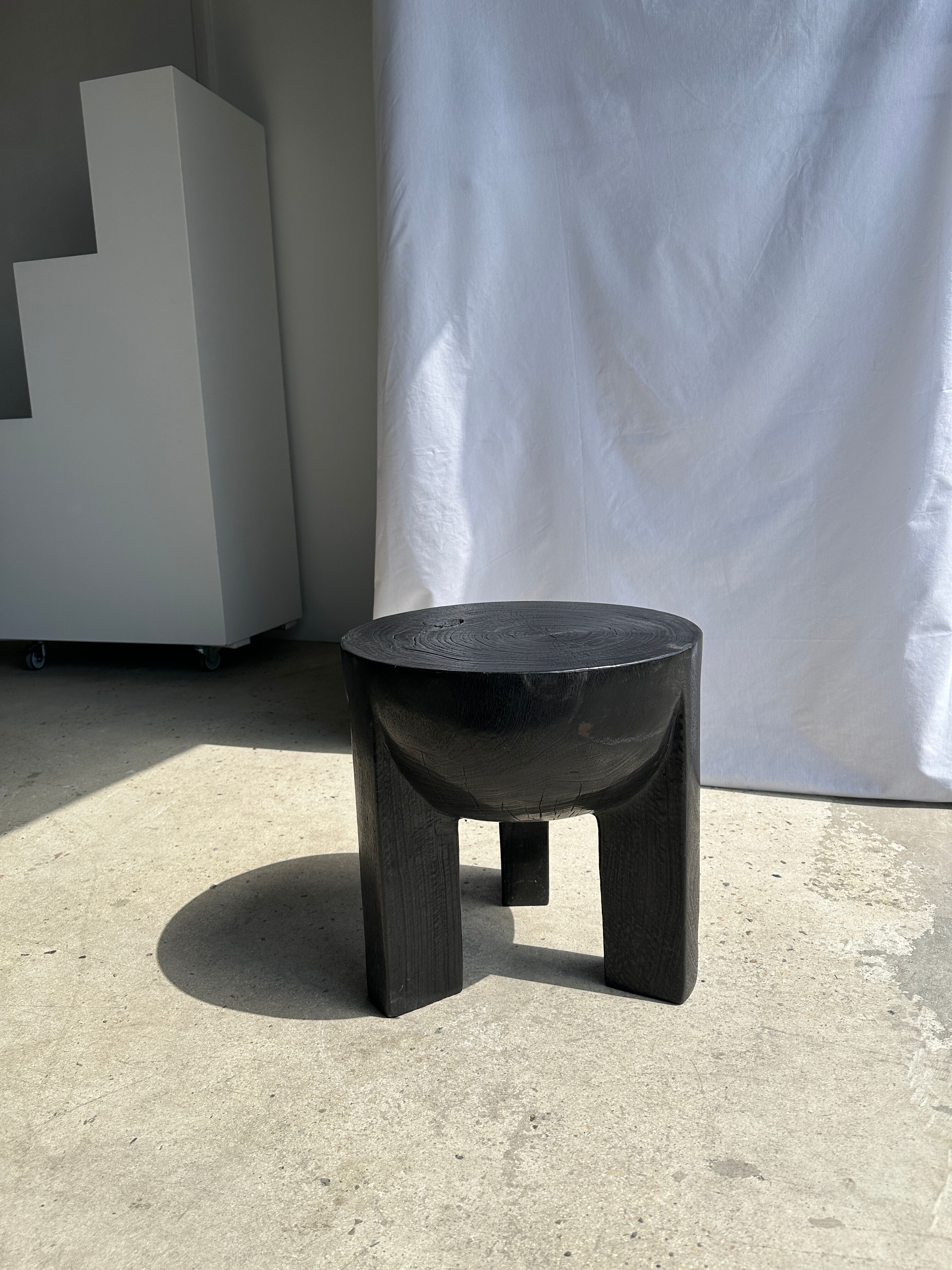 Black mango wood tripod side table with a semi-spherical top, height: 45 cm, diameter: 44 cm.
