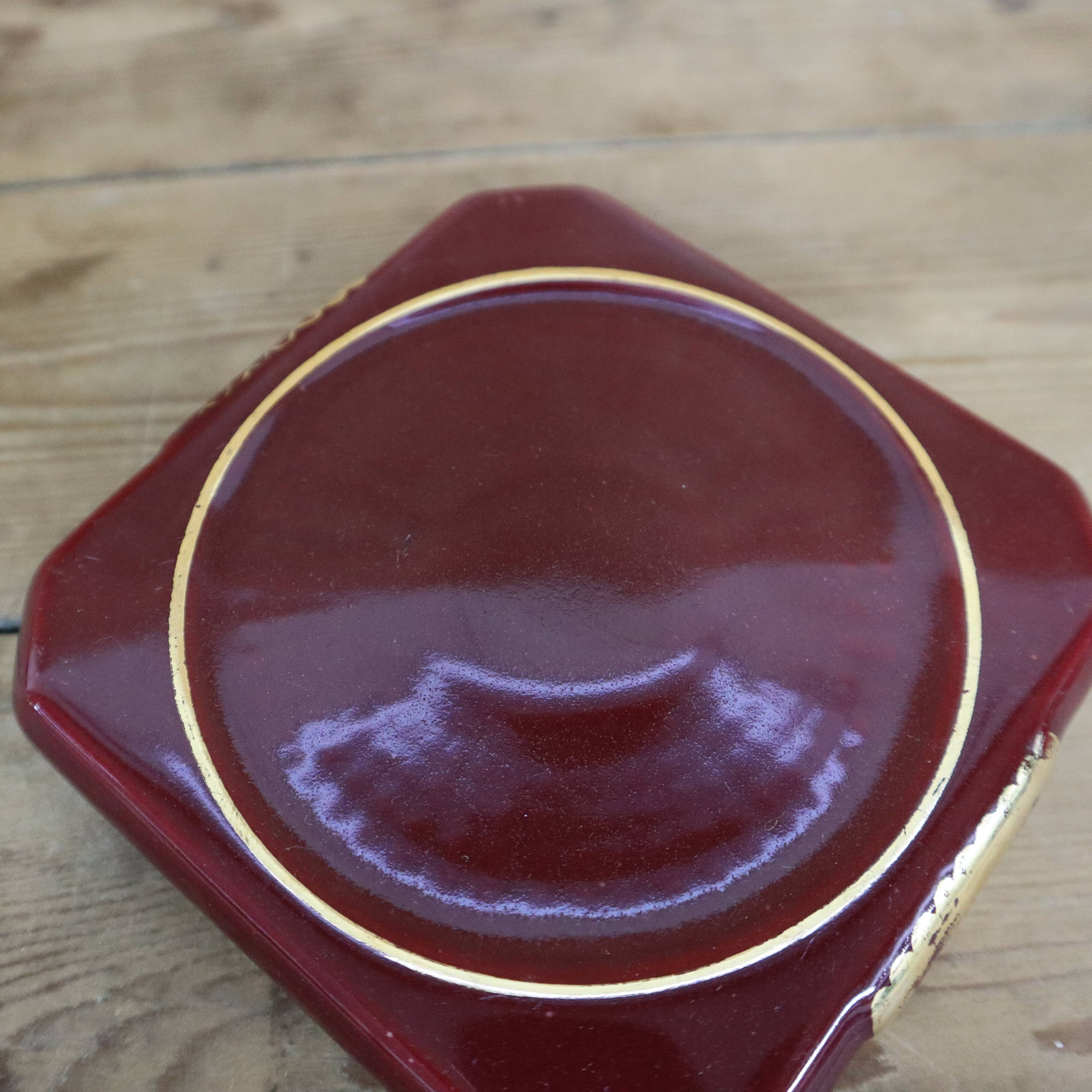 Pair of burgundy ceramic coasters or bottles with gold trim