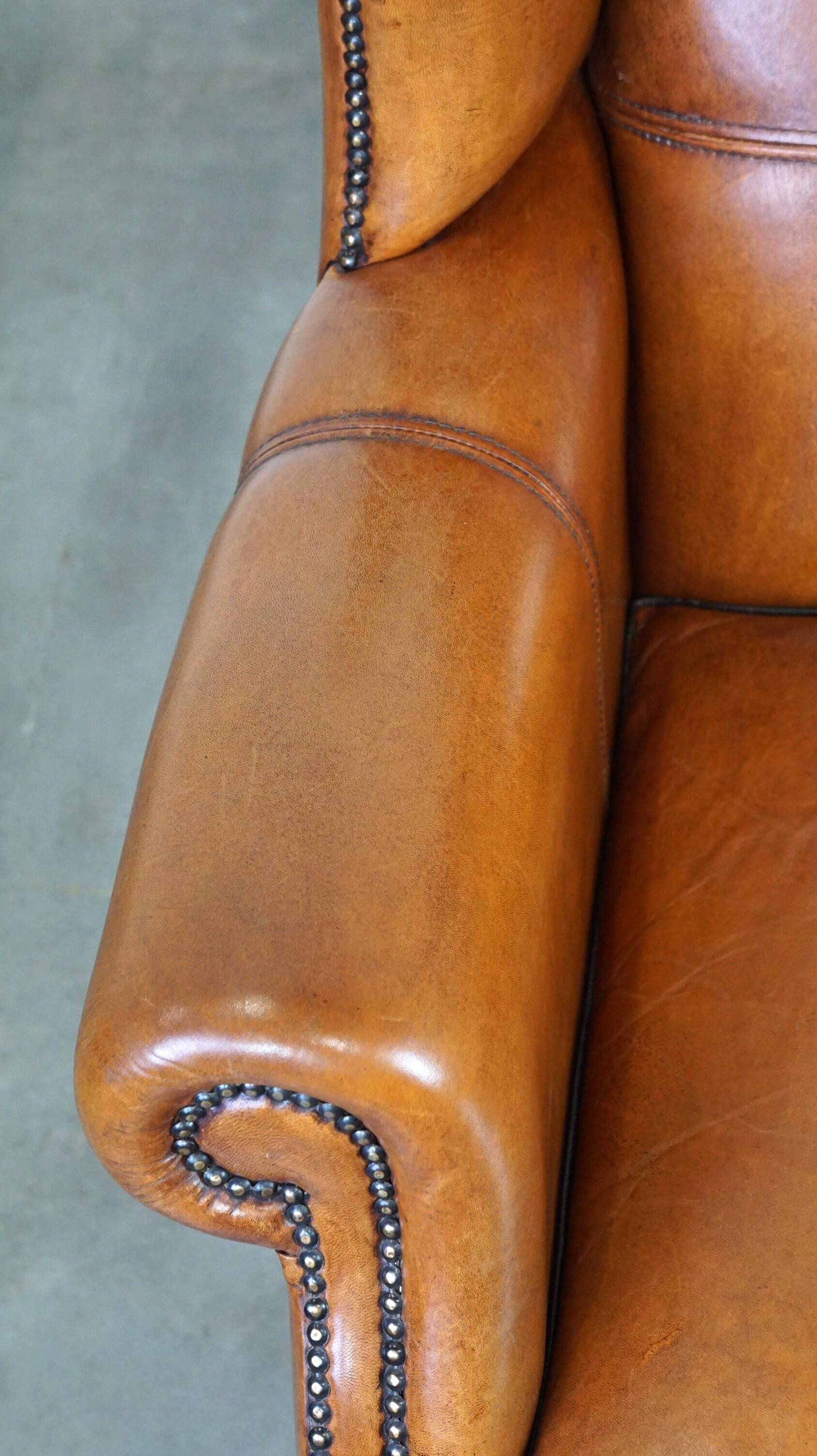 Très beau fauteuil à oreilles en cuir de mouton avec des détails époustouflants