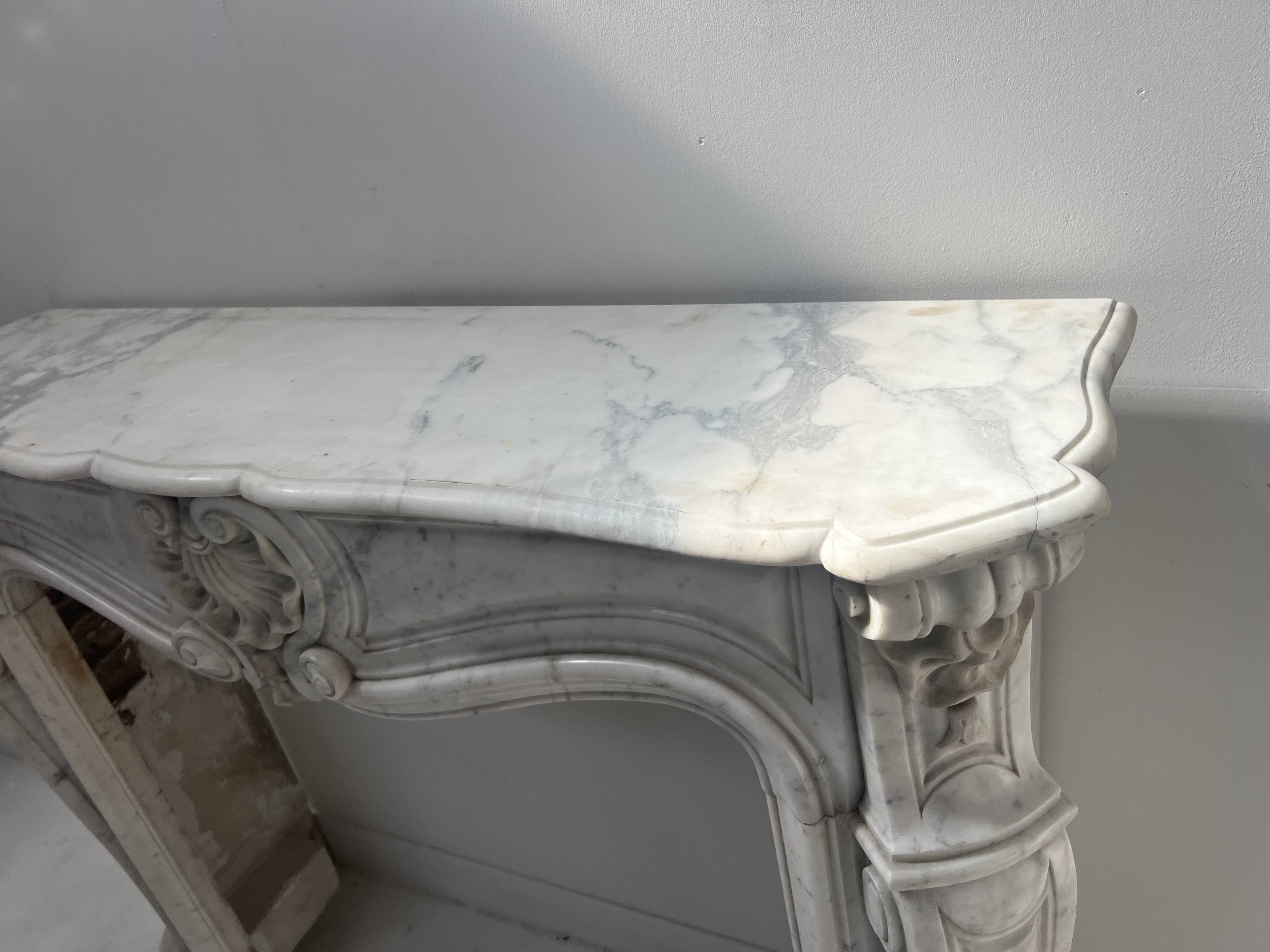 Louis XV style fireplace in veined white Carrara marble, 19th century.