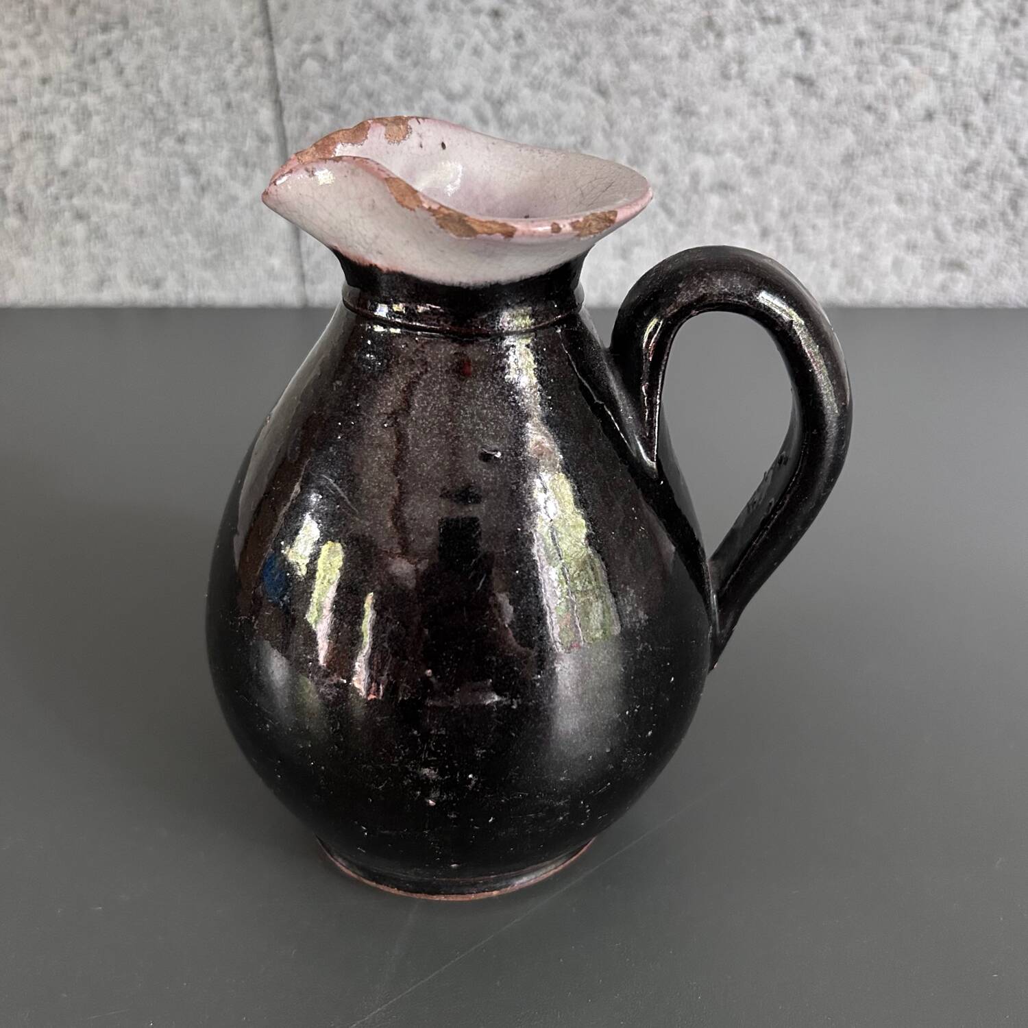 Antique black pitcher with white collar
