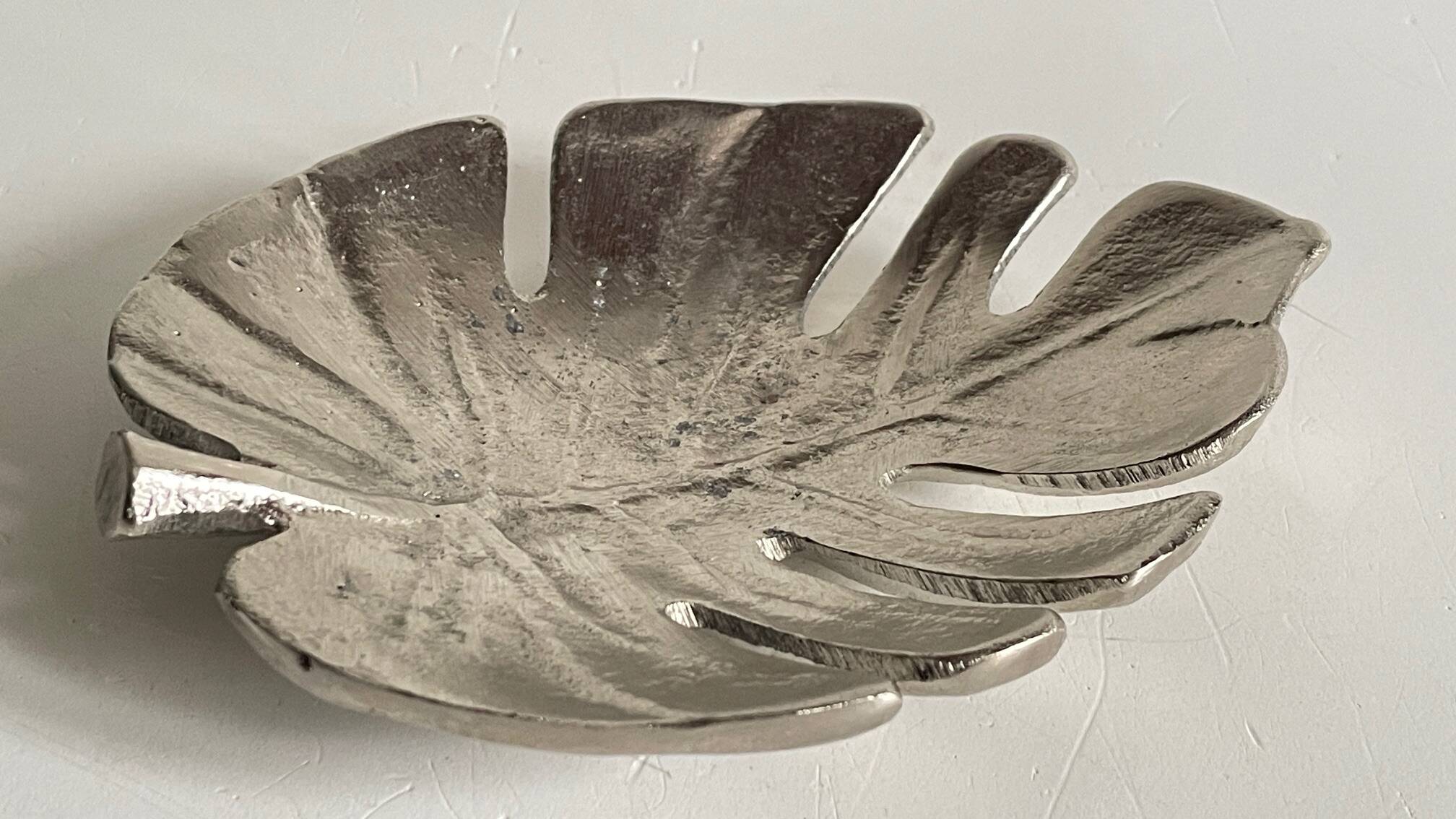 Leaf-shaped metal pocket emptier