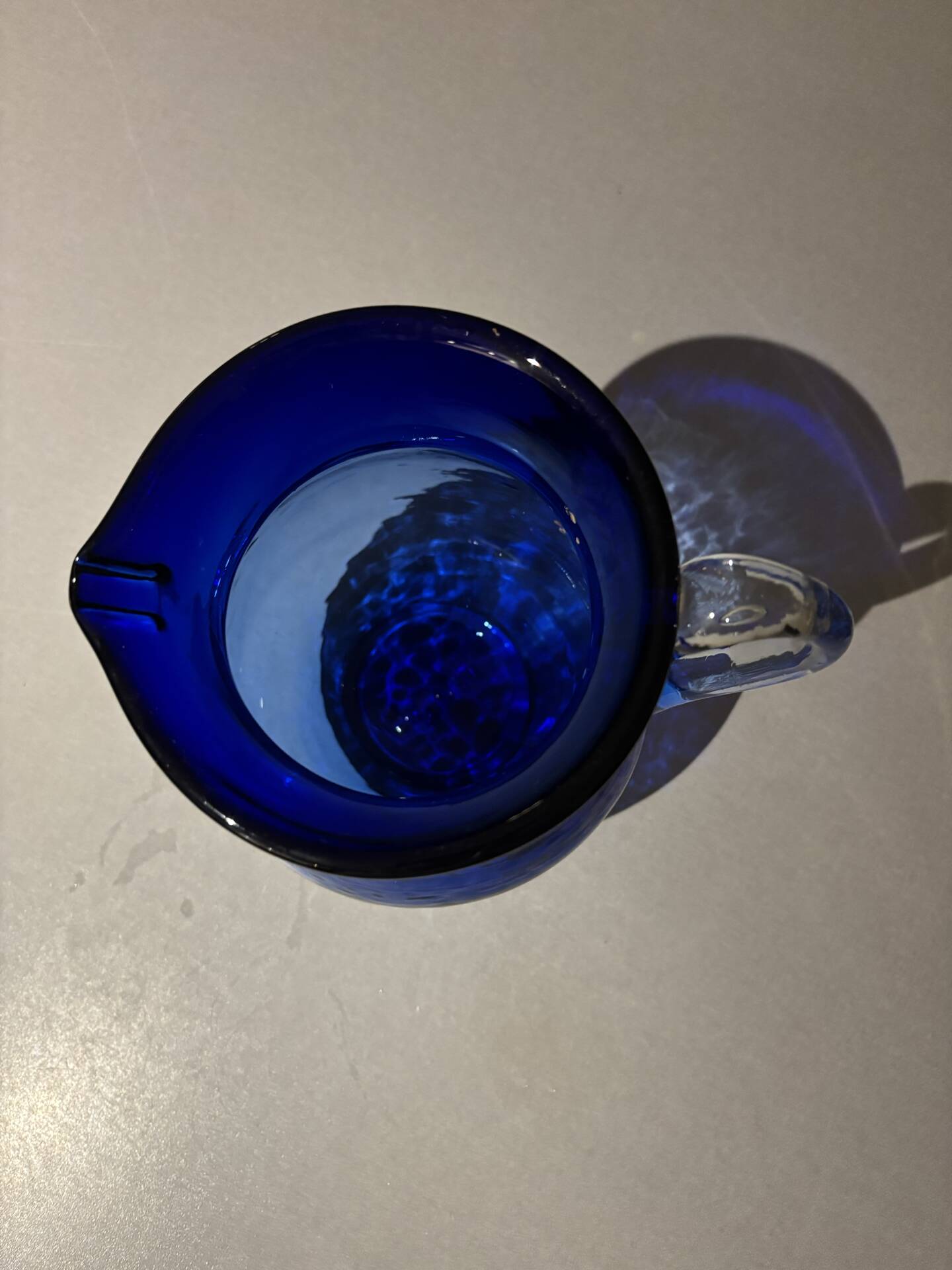Vintage cobalt blue blown glass jug with a transparent handle.