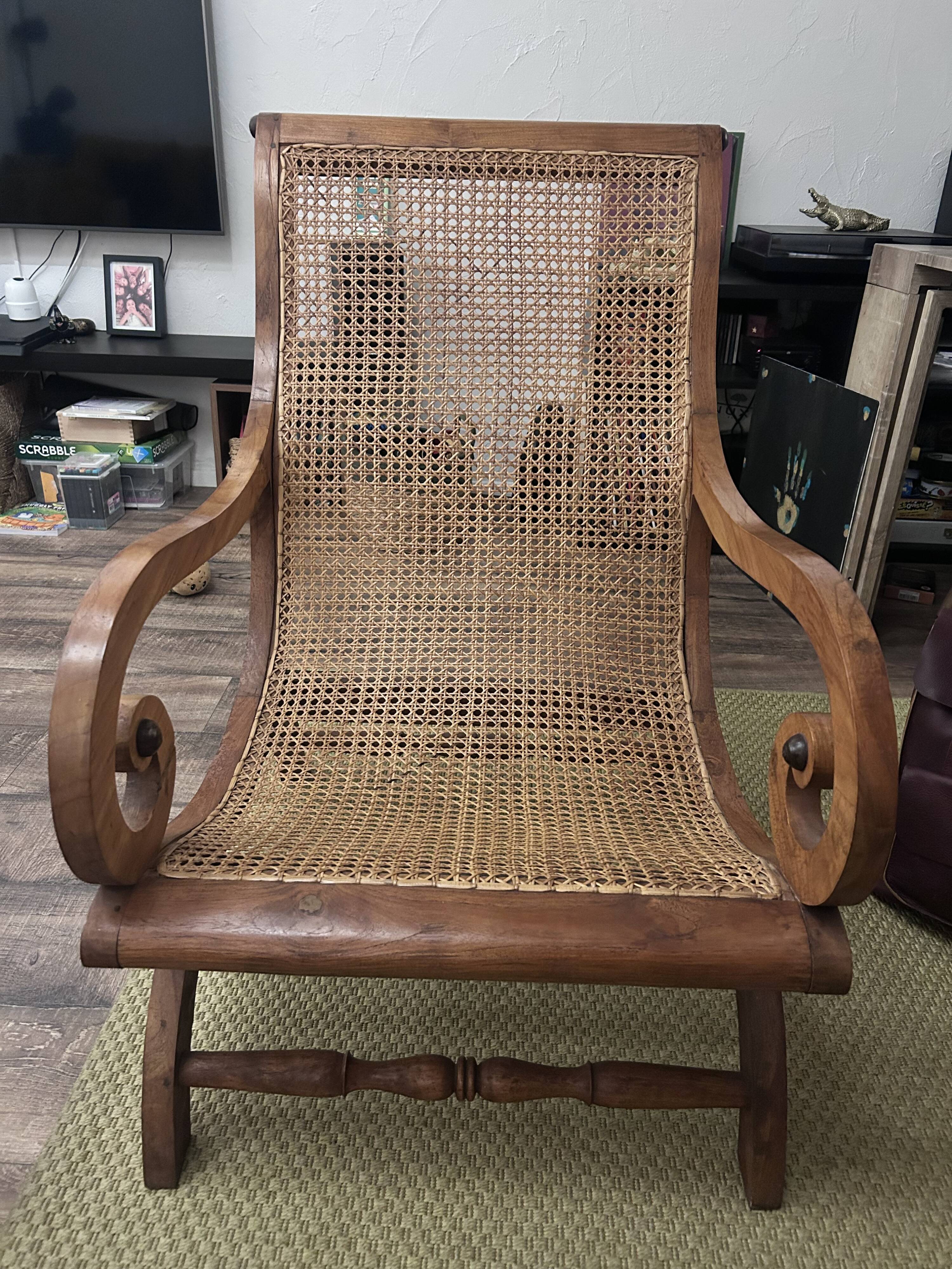 Colonial planter's armchair in solid teak, scroll armrests, caned seat.
