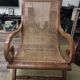 Colonial planter's armchair in solid teak, scroll armrests, caned seat.