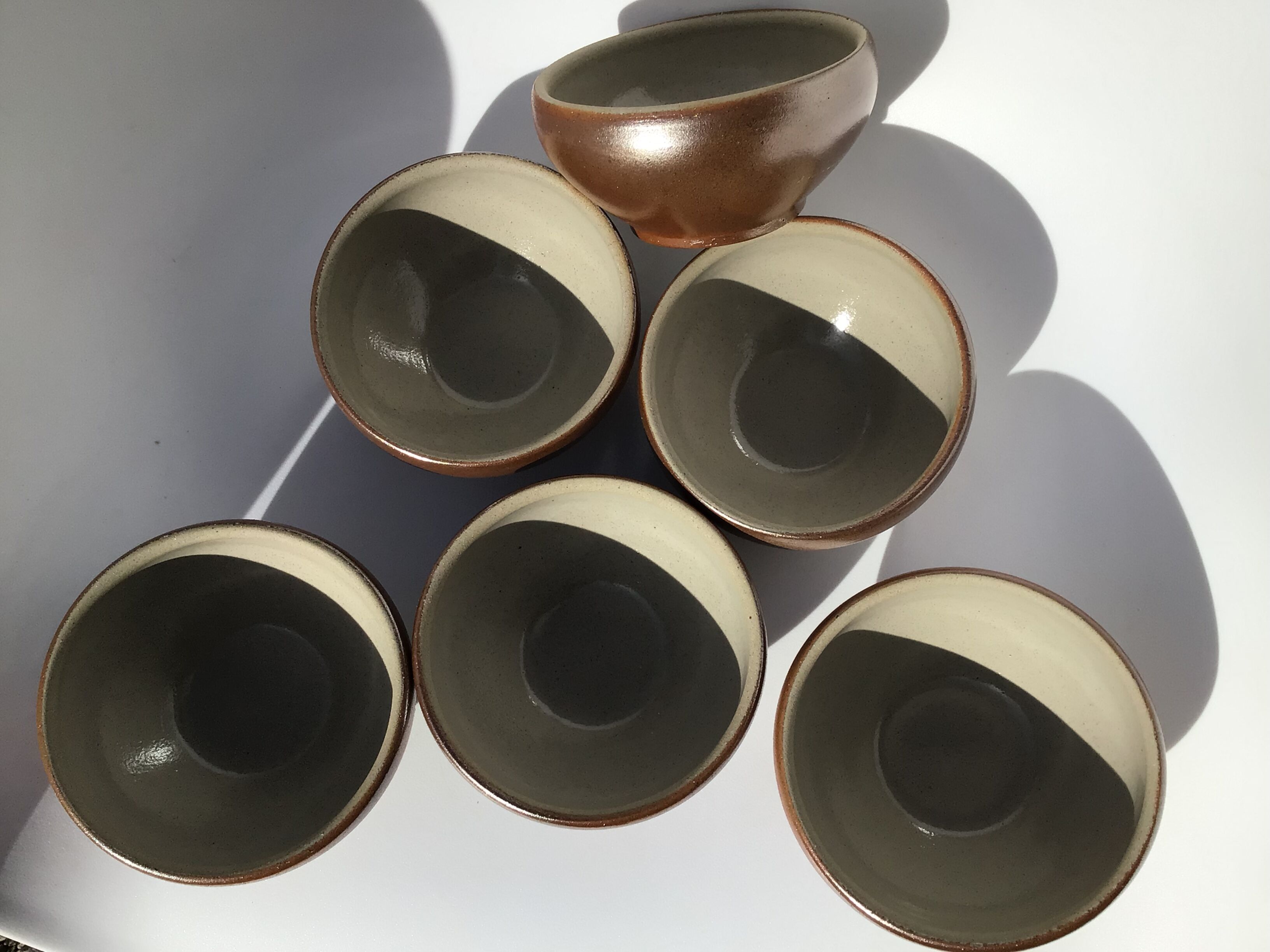 6 iridescent brown sandstone bowls inside grey