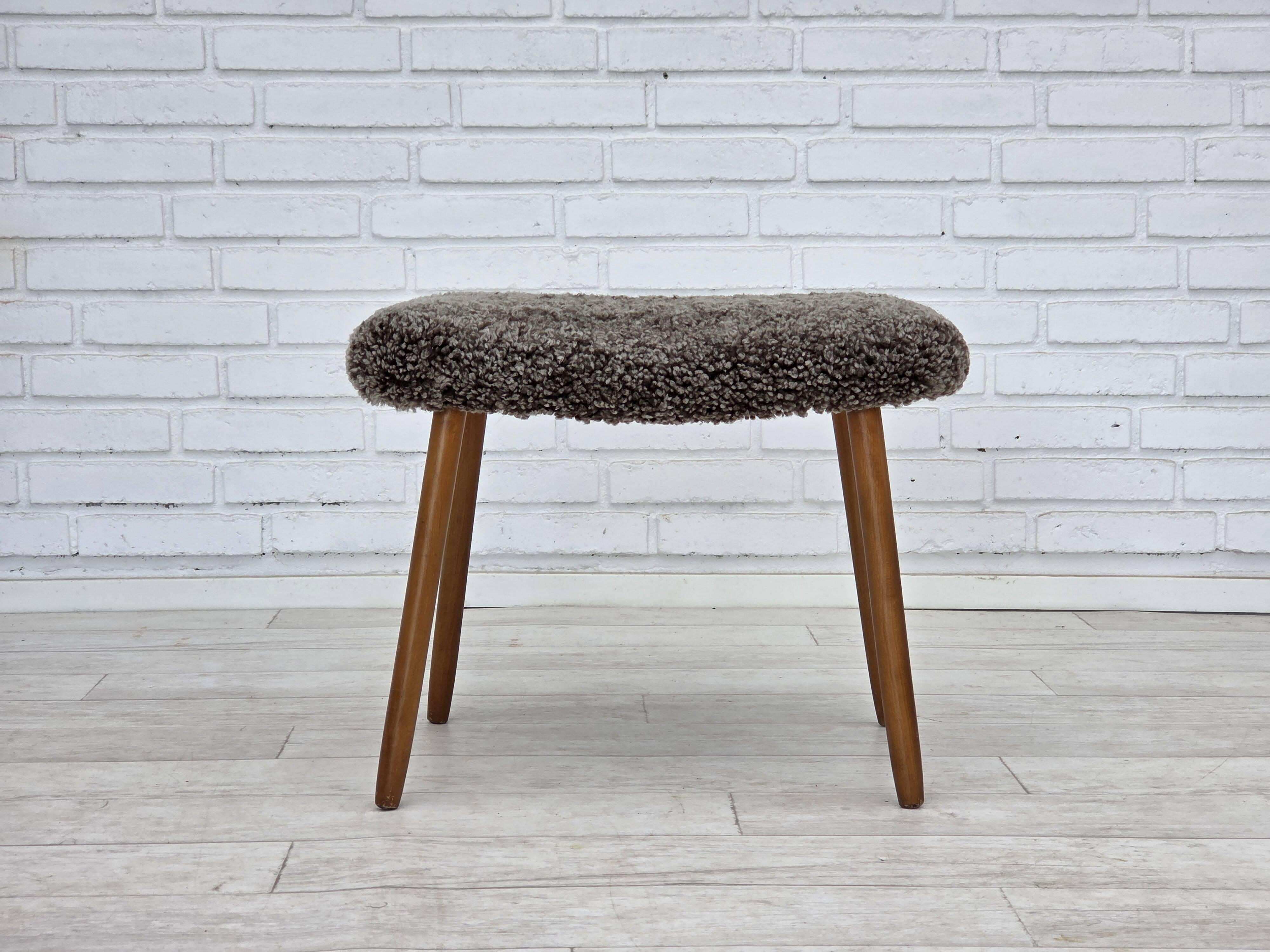 1960s, reupholstered Danish armchair, with stool, genuine sheepskin.