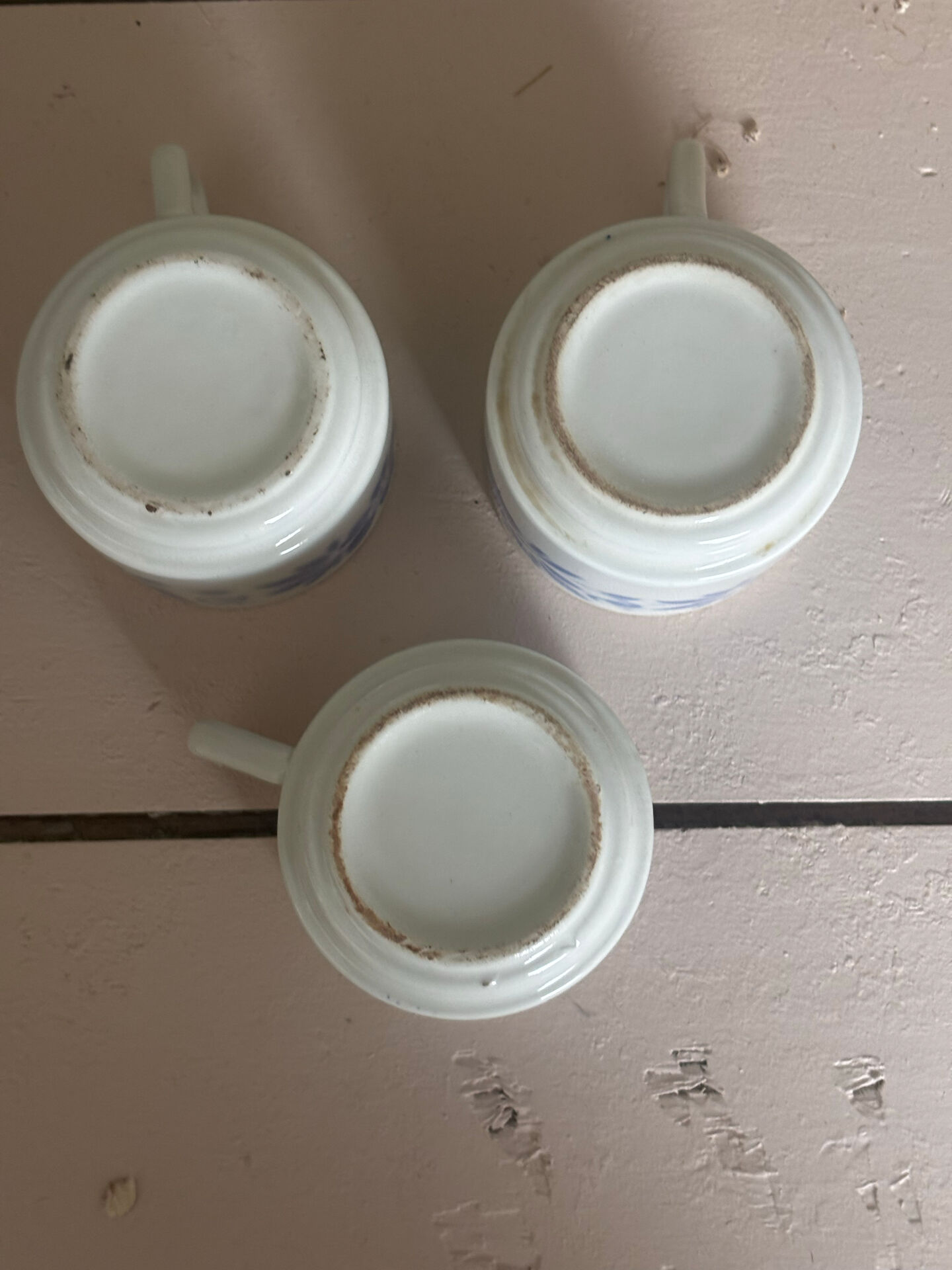 Set of 3 antique ceramic cups with blue floral pattern.