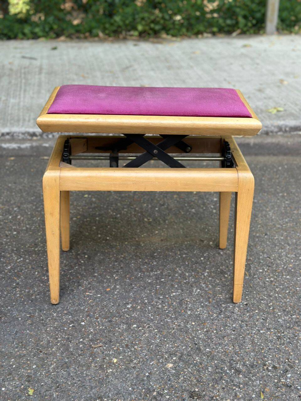 Adjustable piano stool in light beech and purple velvet.