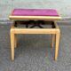 Adjustable piano stool in light beech and purple velvet.