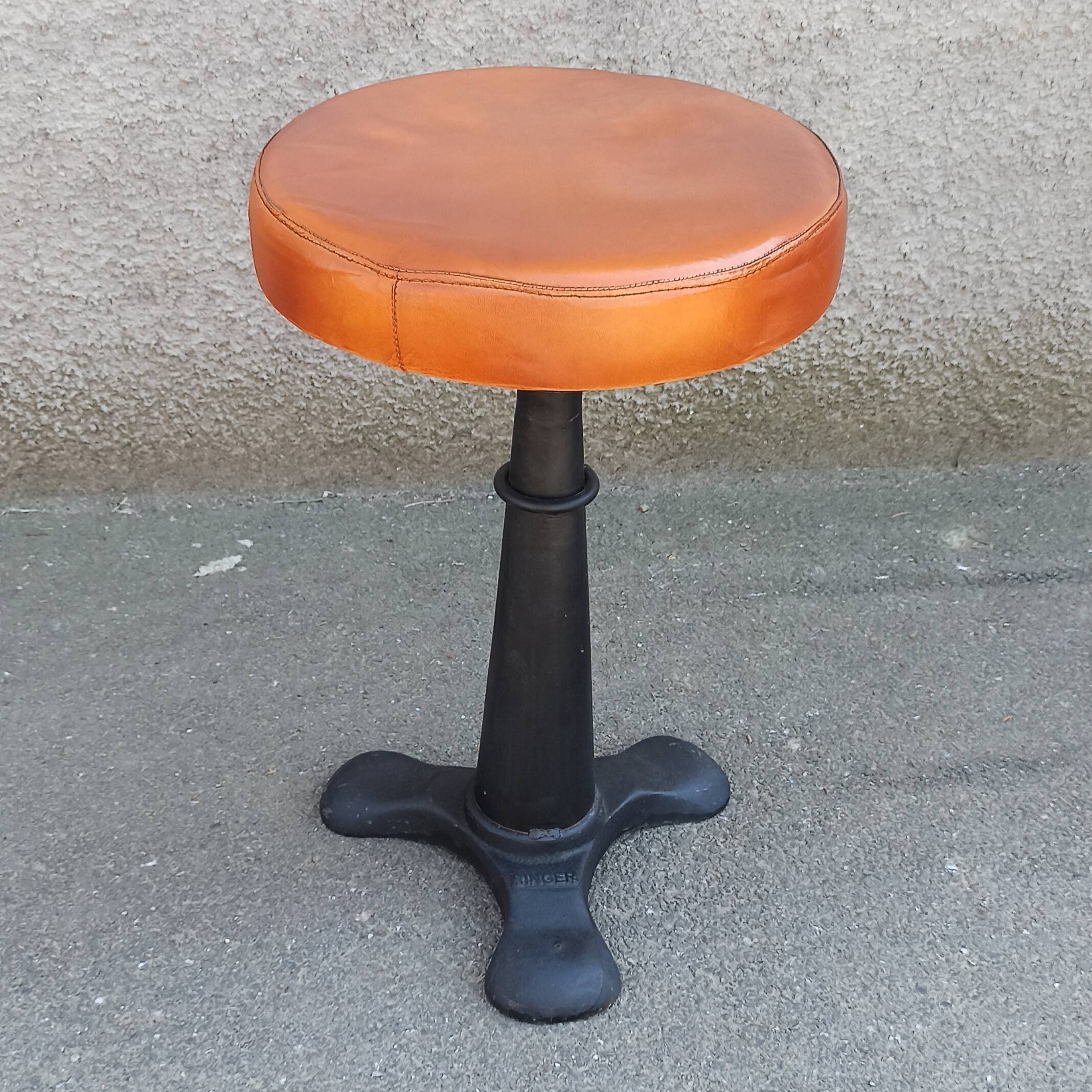 Height-adjustable leather stool with cast iron base