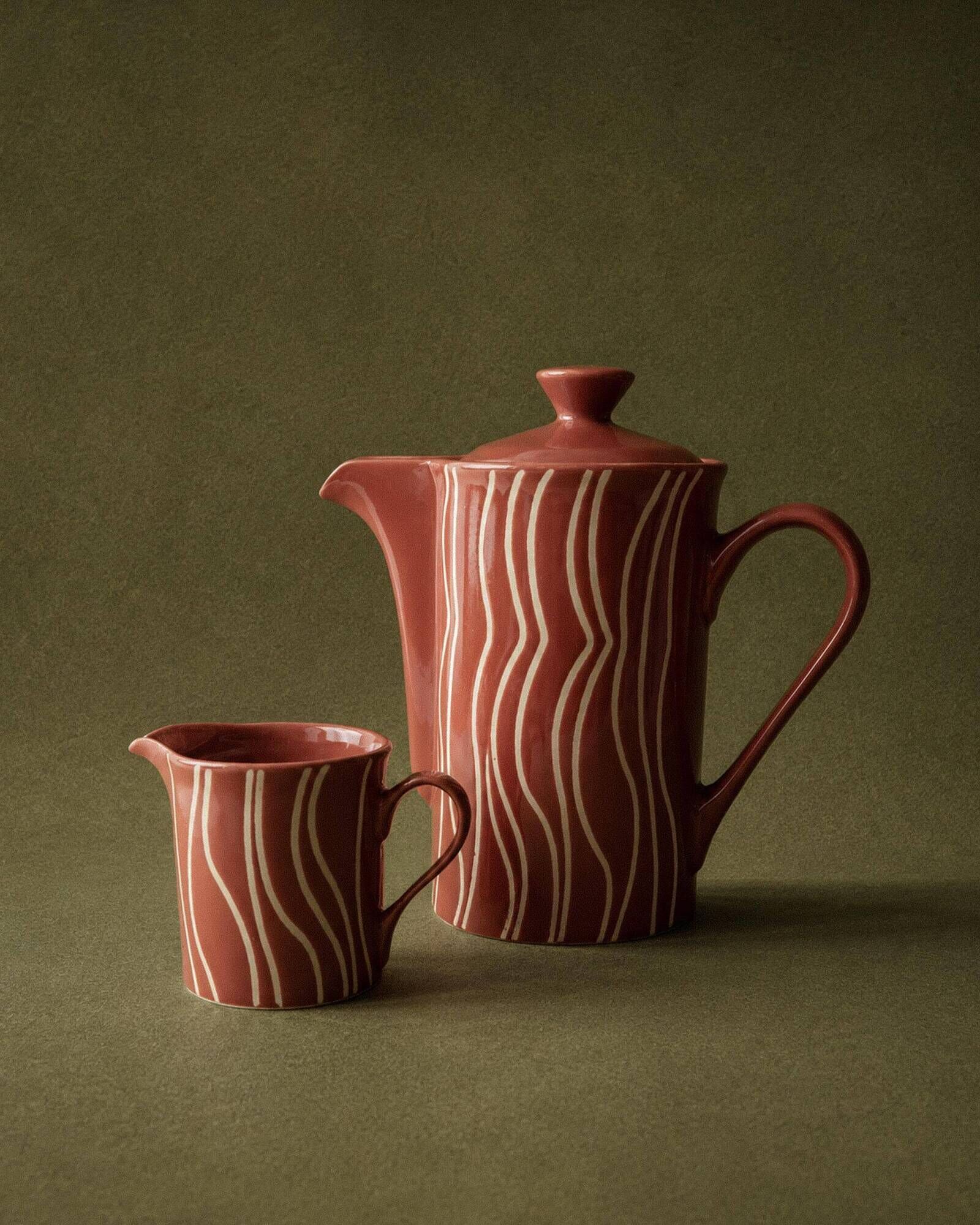 Vintage tea or coffee service in 1970s ceramic, teapot with lid and milk jug, rust orange with retro striped pattern, mid-century decoration, gift idea.