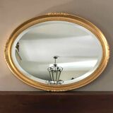 Beveled oval mirror with carved gilded wood frame