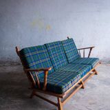 Canapé 3 places en chêne style années 50, avec tissu à carreaux vert-bleu et accoudoirs à fuseaux tournés.