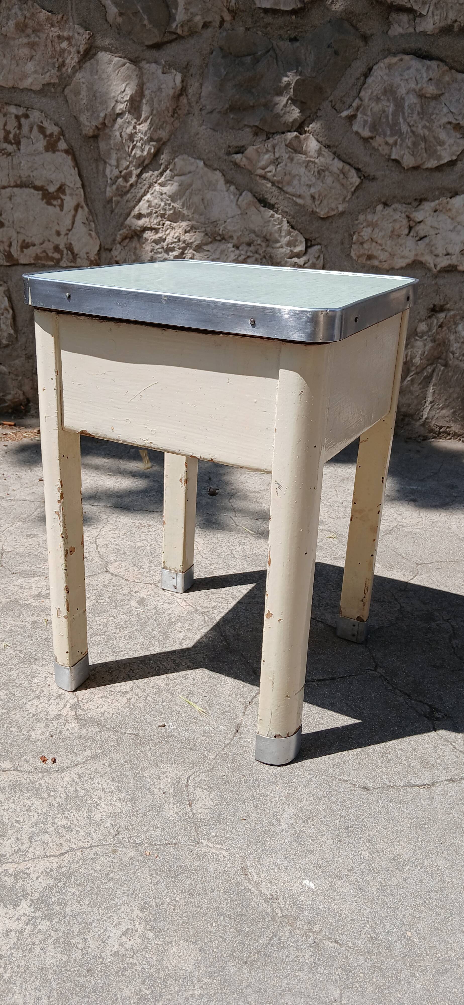 Shoe polish stool with round top and aluminum legs.