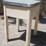 Shoe polish stool with round top and aluminum legs.